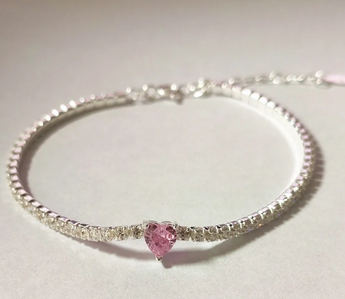 Pulsera tenis de Plata 925 con cierre seguro y corazón rosa central, vista detalle sobre fondo blanco