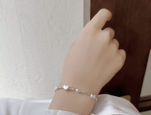 Pulsera con Corazón de Plata y Perla de Agua Dulce Mostrada por Modelo