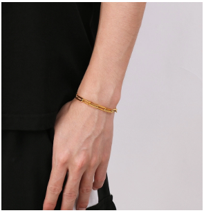 Pulsera de hombre chapada en oro 18K en brazo bajado con camiseta negra.