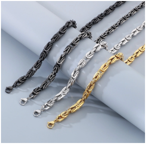 Pulseras de hombre en acero inoxidable 305 con recubrimiento iónico en dorado, plata, acero y negro, dispuestas estiradas sobre un paño de terciopelo gris, fondo elegante y minimalista.