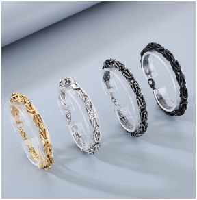 Conjunto de 4 pulseras de hombre en acero inoxidable 305, chapado en oro 18K, color dorado, plata, acero y negro, expuestas en un soporte individual sobre fondo gris claro