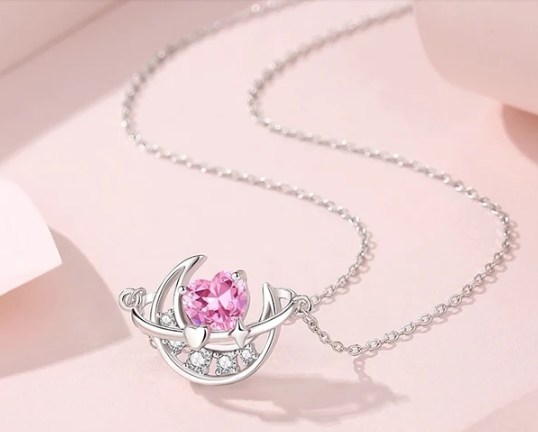Detalle de la luna con zirconitas blancas y corazón rosa en el centro