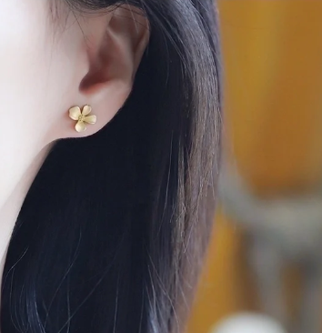 Detalle de pétalos desiguales en pendientes de flor chapados en oro 18K