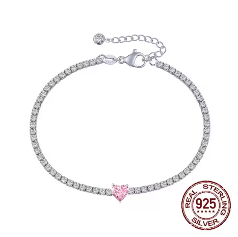 Video mostrando la pulsera tenis con corazón rosa sobre muñeca, reflejando luz en las circonitas y el brillo del baño de rodio.