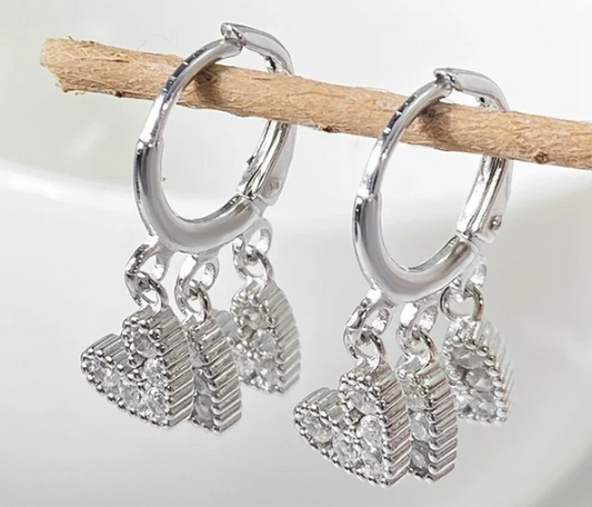 Video de pendientes de aro con tres charms de corazón en zirconitas y chapado en oro 18K en movimiento