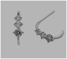 Pendientes básicos de plata girando sobre fondo neutro, mostrando su brillo y simplicidad desde distintos ángulos.