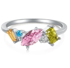  Anillo geométrico multicolor girando sobre fondo neutro, destacando el brillo y los colores de las zirconitas