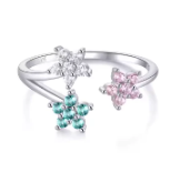 Anillo de plata con tres estrellas de circonita multicolor girando sobre fondo blanco