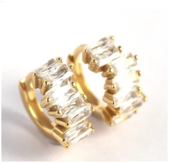 Pendientes girando lentamente sobre fondo negro con luz puntual que resalta el brillo de las zirconitas.