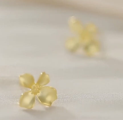Pendientes flor de oro girando con brillo en pétalos de distintas alturas