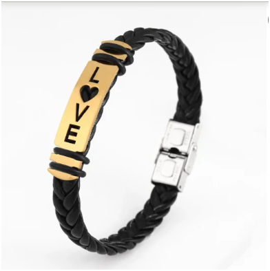 pulsera de cuero trenzada a mano con diseño de love ancho en acero inoxidable dorado 304 sobre fondo blanco